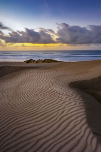 Scenic view of beach against sky during sunset