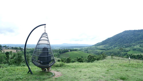 Ferris wheel on field against sky