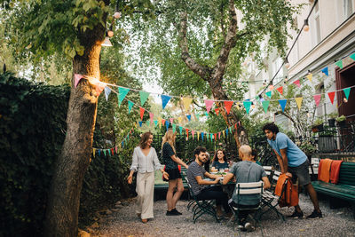 Multi-ethnic male and female friends enjoying in backyard during garden party