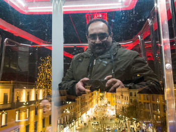 Full length portrait of man in illuminated city