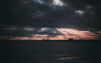 Scenic view of sea against dramatic sky during sunset