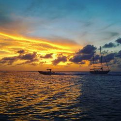 Sailboat sailing on sea against sky during sunset