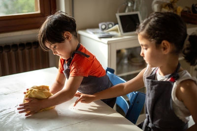Little girls with dark hair preparing the dough