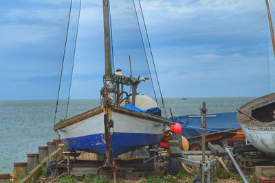 Sailboats moored on sea against sky