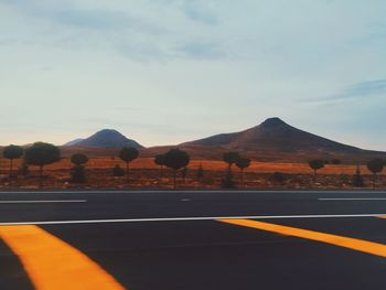 Road by mountain against sky