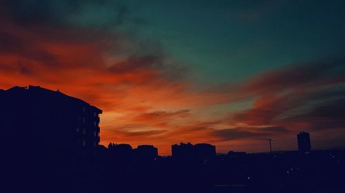 Silhouette buildings against sky during sunset