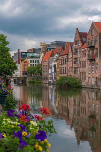 Reflection of buildings on river against sky