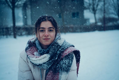 Portrait of smiling young woman standing on snow