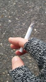 Close-up of hand holding cigarette