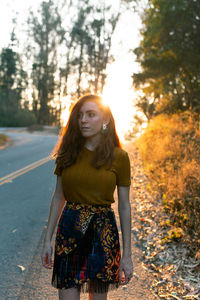 Portrait of smiling young woman against trees