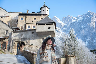 Woman in winter clothes in front of an medieval castle.