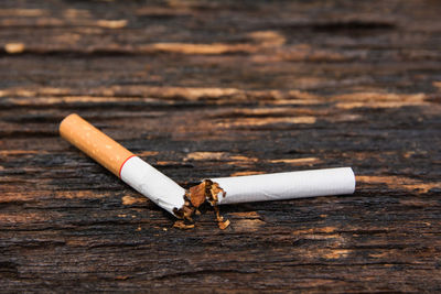 Close-up of broken cigarette on wooden table