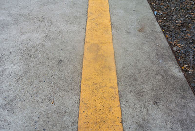 High angle view of yellow arrow symbol on road