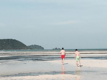 Rear view of man and boy at beach