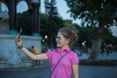 Portrait of woman photographing through smart phone