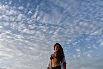 Portrait of smiling woman standing against sky