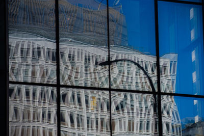 Low angle view of glass building against sky