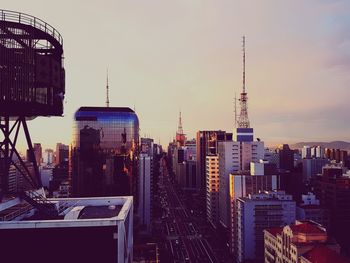 Buildings in city against sky during sunset