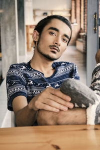 Portrait of young man sitting at home