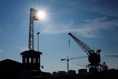 Low angle view of silhouette crane against sky during sunset