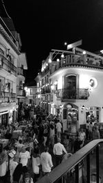 Crowd on illuminated city against sky at night