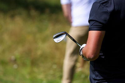 Midsection of man playing golf course