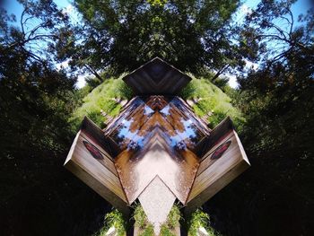 Low angle view of traditional windmill in forest against sky