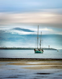 Historic sailboat anchored in bay harbor with storm approaching