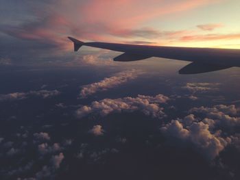 Cropped image of airplane flying over cloudy sky