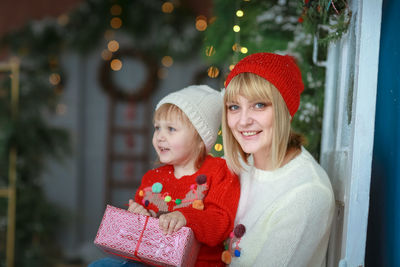 Portrait of smiling young woman holding christmas tree