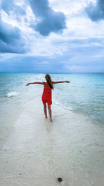 Full length of woman standing at beach against sky in zanzibar tanzania 