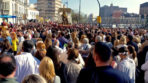 Crowd in city against sky