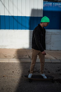 Full length of man standing against wall