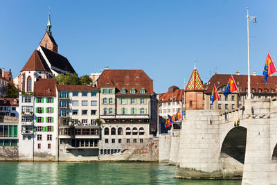 Buildings at waterfront against blue sky