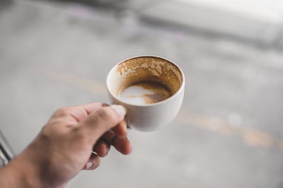 Close-up of hand holding coffee cup