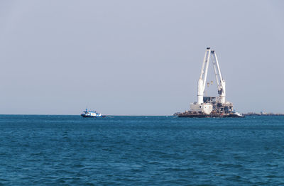 Sailboat sailing on sea against clear sky