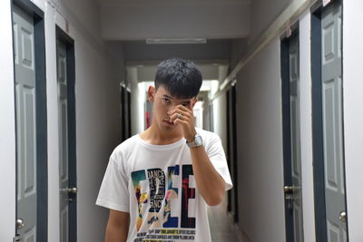 Portrait of young man standing in corridor of building