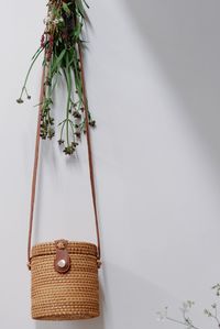 Close-up of plant hanging on table against wall