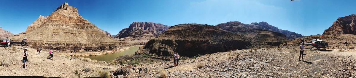 Panoramic view of people on rock against sky