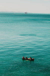 People sailing on sea against sky