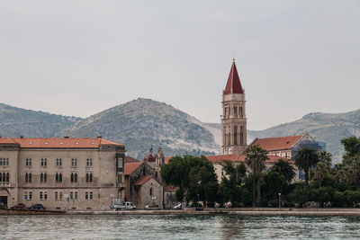 View of buildings against sky with mountain in background