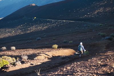 Rear view of woman walking on mountain against sky