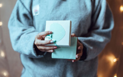 Midsection of woman holding gift box against illuminated lights