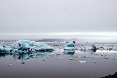 Ice floating on sea against sky during winter