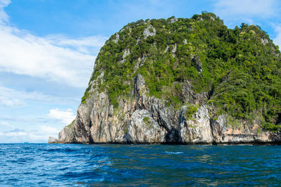 Scenic view of rocky mountain in sea against sky at phi phi islands