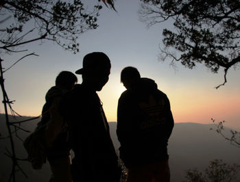 Silhouette people standing against sky during sunset