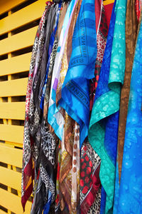 Close-up of multi colored umbrellas hanging against blue wall