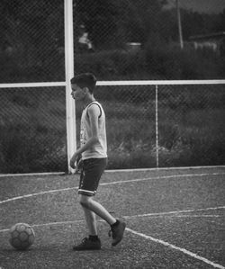 Boy playing with ball on field