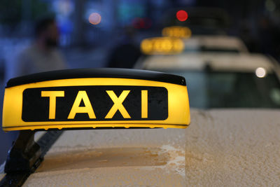 Close-up of yellow sign on road in city