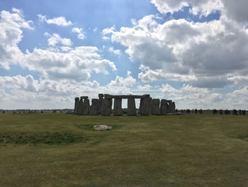 Built structure on field against cloudy sky